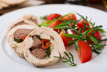 Diet baked chicken rolls stuffed liver, chili and herbs with a salad of tomatoes and arugula. Dietary menu. Proper nutrition.