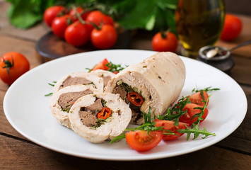 Diet baked chicken rolls stuffed liver, chili and herbs with a salad of tomatoes and arugula. Dietary menu. Proper nutrition.