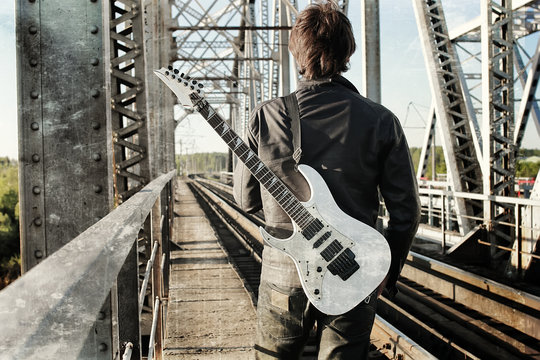 Scratch Effect On Photo Men With Guitar On A Railroad