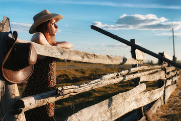 girl in a cowboy hat at the fence