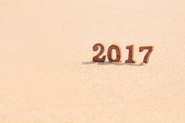 Wood number 2017 on beach background idea, happy new year concept