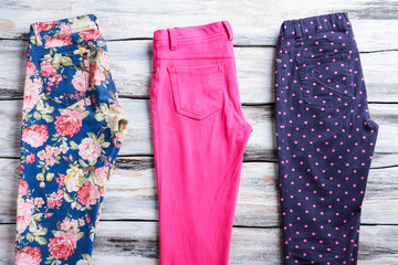 Bright pink and navy pants. Trousers with stylish print. Woman's garments on white shelf. Regular fit pants on sale.