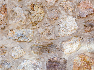 Ancient roughness stone wall. A lot of different stones. Beige texture. Can be used as background