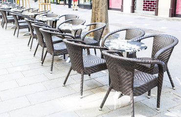 Row of little tables with chairs  in open cafe