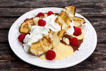Banana slip dessert with raspberries, mint under whipped cream