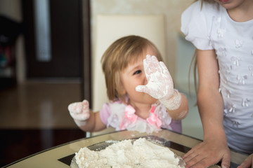 Obraz na płótnie Canvas Child hands mixing flour in the kitchen, child 2 years, healthy eating home cooking