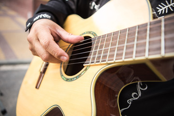 Fototapeta premium A man plays the guitar, close-up of hands. Latin American, Spanish, Mexican musician