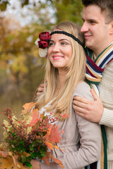 Fototapeta premium Autumn wedding in boho style. Autumn leaf fall, autumnal forest. loving couple, man and woman. orange pumpkin