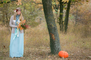 Autumn wedding in boho style. Autumn leaf fall, autumnal forest. Girl with a bouquet of autumn leaves and berries. Thanksgiving Day