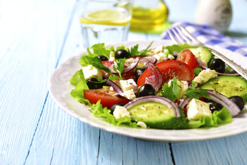 Traditional greek salad on a white plate.