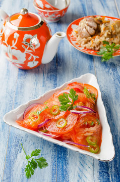 Vegetable salad from tomatoes with onions and hot peppers