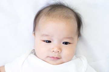 Portrait of a newborn Asian baby on the bed