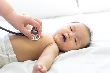 Doctor exams Asian newborn baby with stethoscope in the hospital