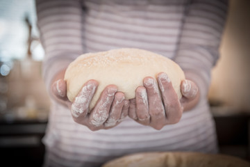 Hands holding finished clean dough