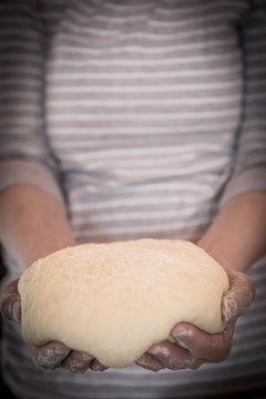 Hands holding finished clean dough