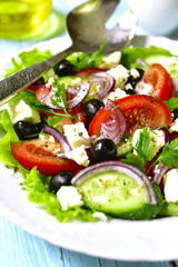 Traditional greek salad on a white plate.