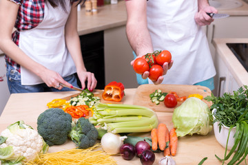 man hold fresh tomato and cooking together with woman
