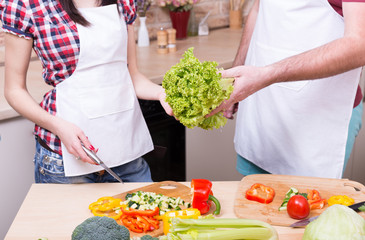 man and woman cooking together on kitchen