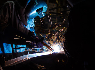 worker with protective mask welding metal