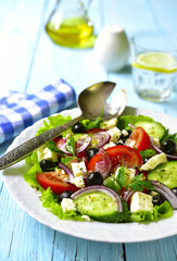 Traditional greek salad on a white plate.