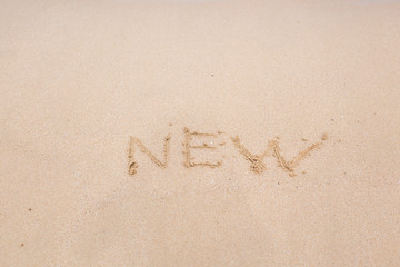 New handwritten in sand on a beach