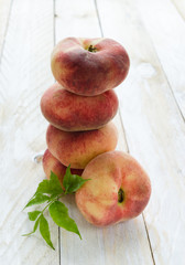 Saturn peaches or UFO, donut, flat peaches on white wood boards 