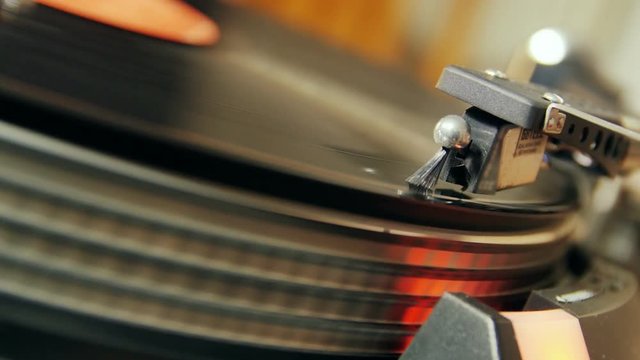 old  record playing on turntable redord,stylus needle going down