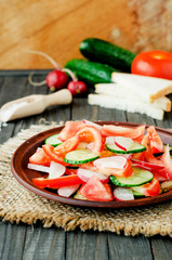 
healthy salad with fresh ripe summer vegetables , tomato, cucumber , radishes , spices and white toast on a wooden background