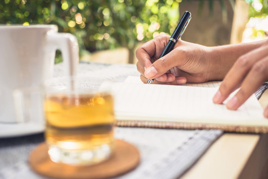 Writing outdoor in the garden with cup of tea