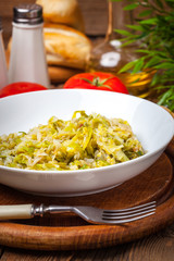 Fried cabbage greens and onion in wooden table.