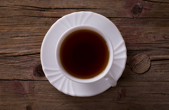 Tasse Tee auf braunem Hintergrund aus Holz - Ansicht von oben.