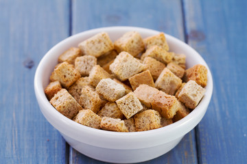 croutins in white dish on blue wooden background