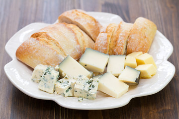 cheese with bread on white dish on brown background