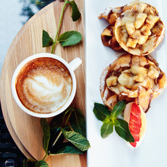 pancakes with fruit and coffee on wooden background. Beautiful restaurant serving the dessert