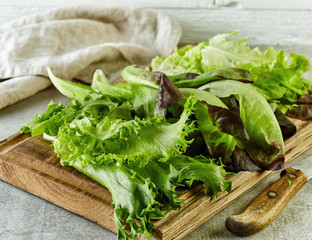 fresh lettuce on wooden cutting board © Mara Zemgaliete