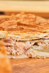 A piece of pie stuffed with salmon on a wooden table