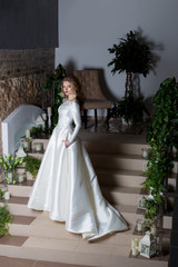Obraz na płótnie Canvas beautiful sweet girl elegant bride in an elegant wedding platestoit on the stairs