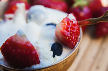 Delicious ice cream with strawberry pieces and blueberries