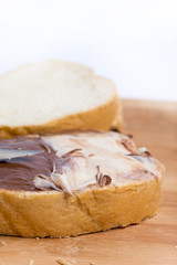 Chocolate hazelnuts cream on the bread, closeup macro image
