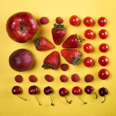 composition en carré de fruits rouges sur un fond jaune