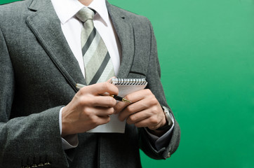 businessman in a suit with a notebook and pen in the hands