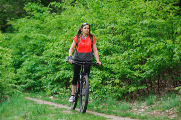 Girl riding a bike in the woods