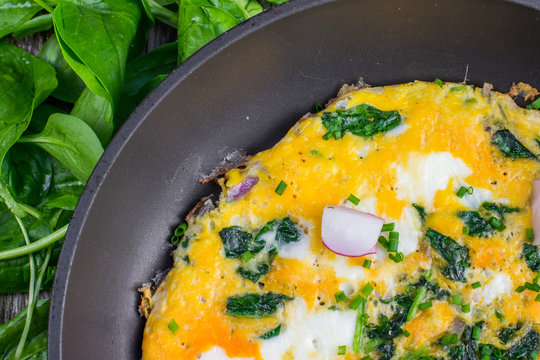 Detail on a Spinach Omelette with Radish in the Pan on Wooden Bo