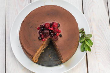 Top View on Sliced Chocolate cake with Ganache and berries fruit