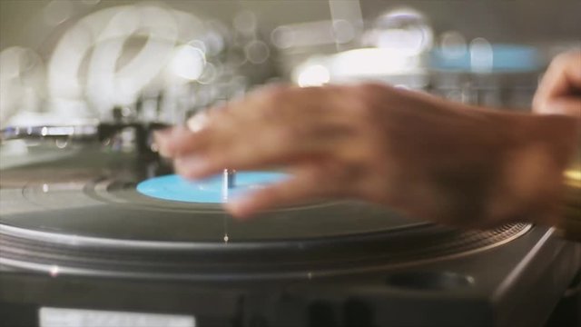 Hand of male DJ spinning turntable on night party. Entertainment. Sound  professional equipment. Player. Close up