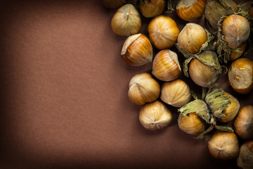 Whole and chopped hazelnuts on brown table