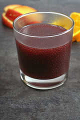 Raspberry Chai Seed drink. In the background, orange and apple slices.