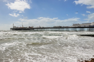 Fototapeta na wymiar View of rough sea and Brighton pier in UK