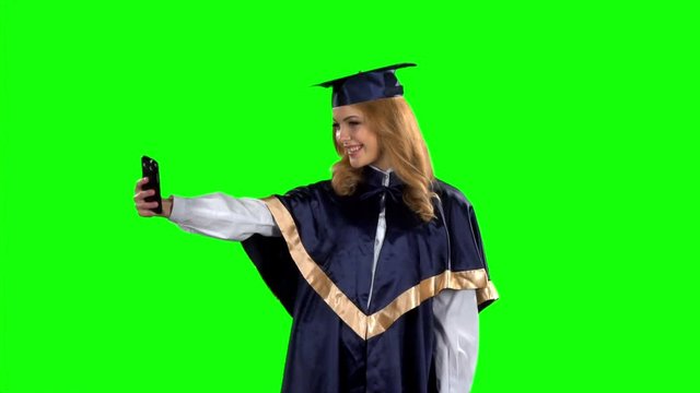 Graduate taking picture with smartphone. Green screen. Slow motion
