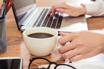 Fototapeta na wymiar Businesswoman using laptop and drink coffee at desk